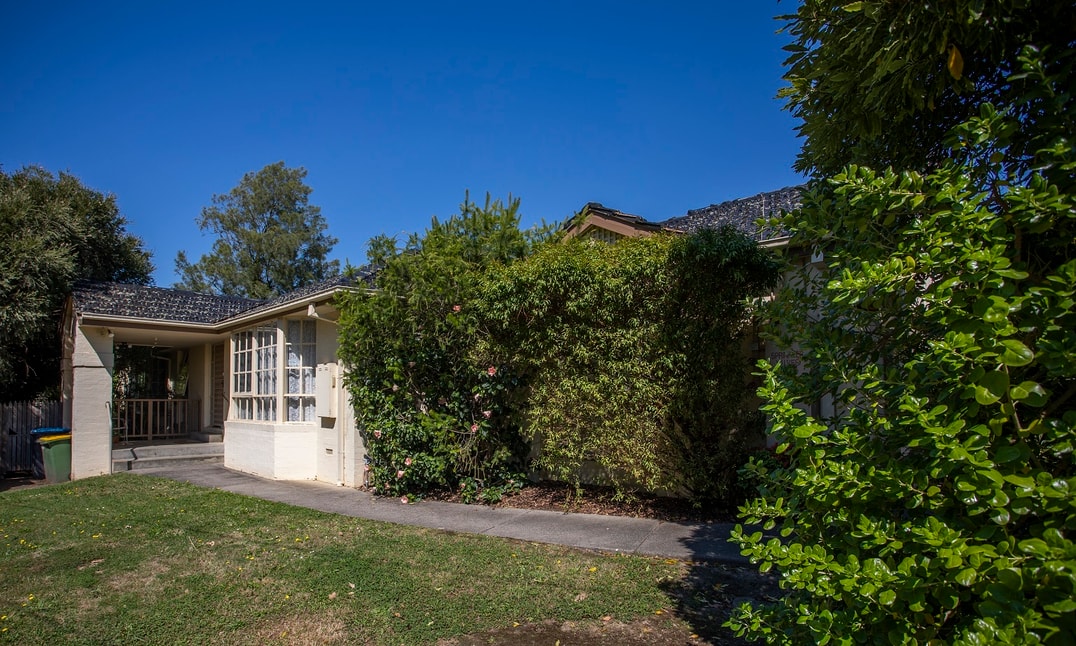Outside of an SDA home in Boronia with tall green shrubbery