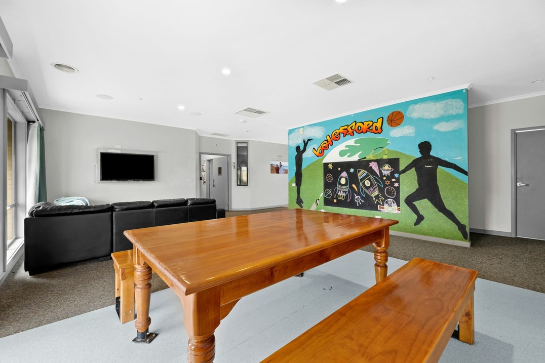 Open plan dining and living room with a sporty basketball feature wall