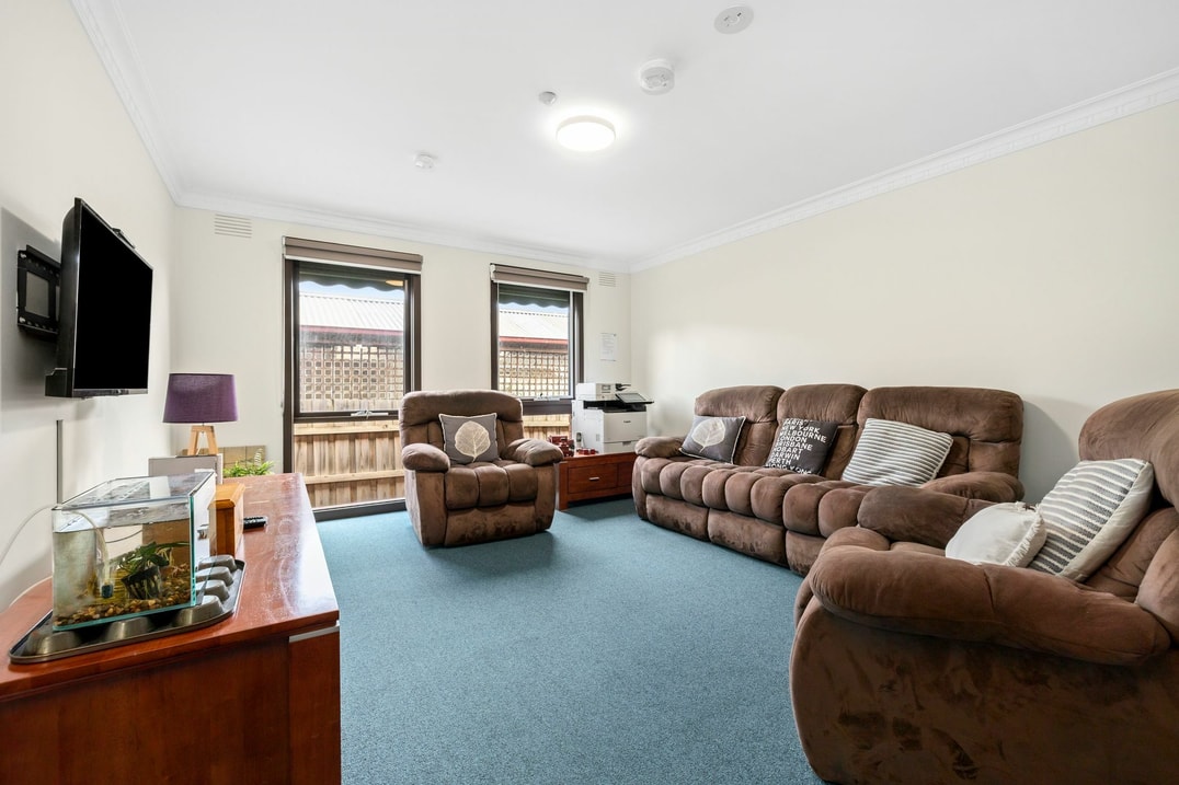 Living room area with brown couches and natural light