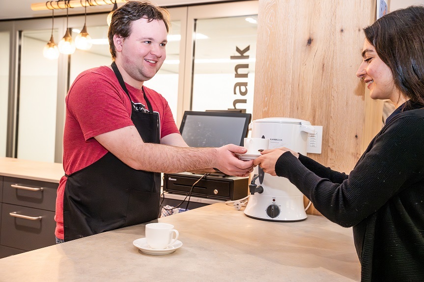 Scope customer giving a woman a coffee.