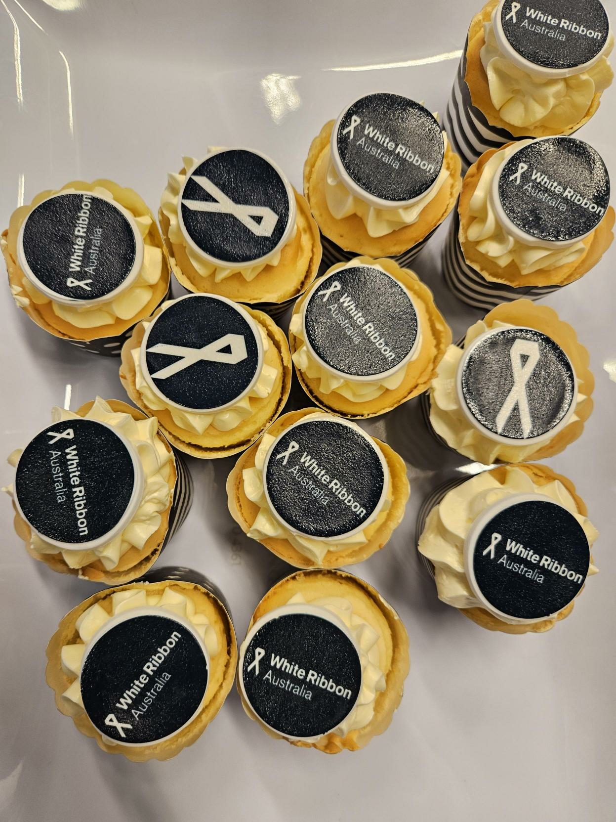 Yellow cupcakes with white ribbon Australia logo on them