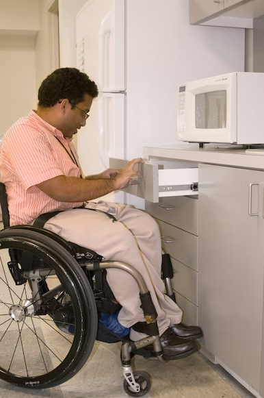 A man in a wheelchair is opening a drawer