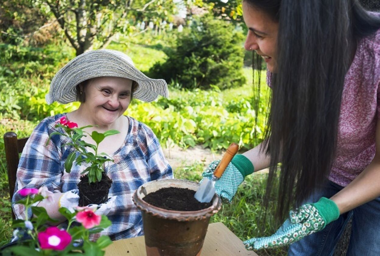 A woman is helping an old lady gardening