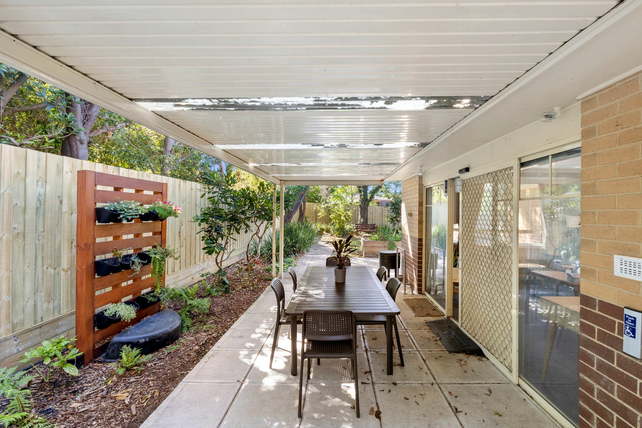 Pergola with a timber vertical garden and outdoor seating