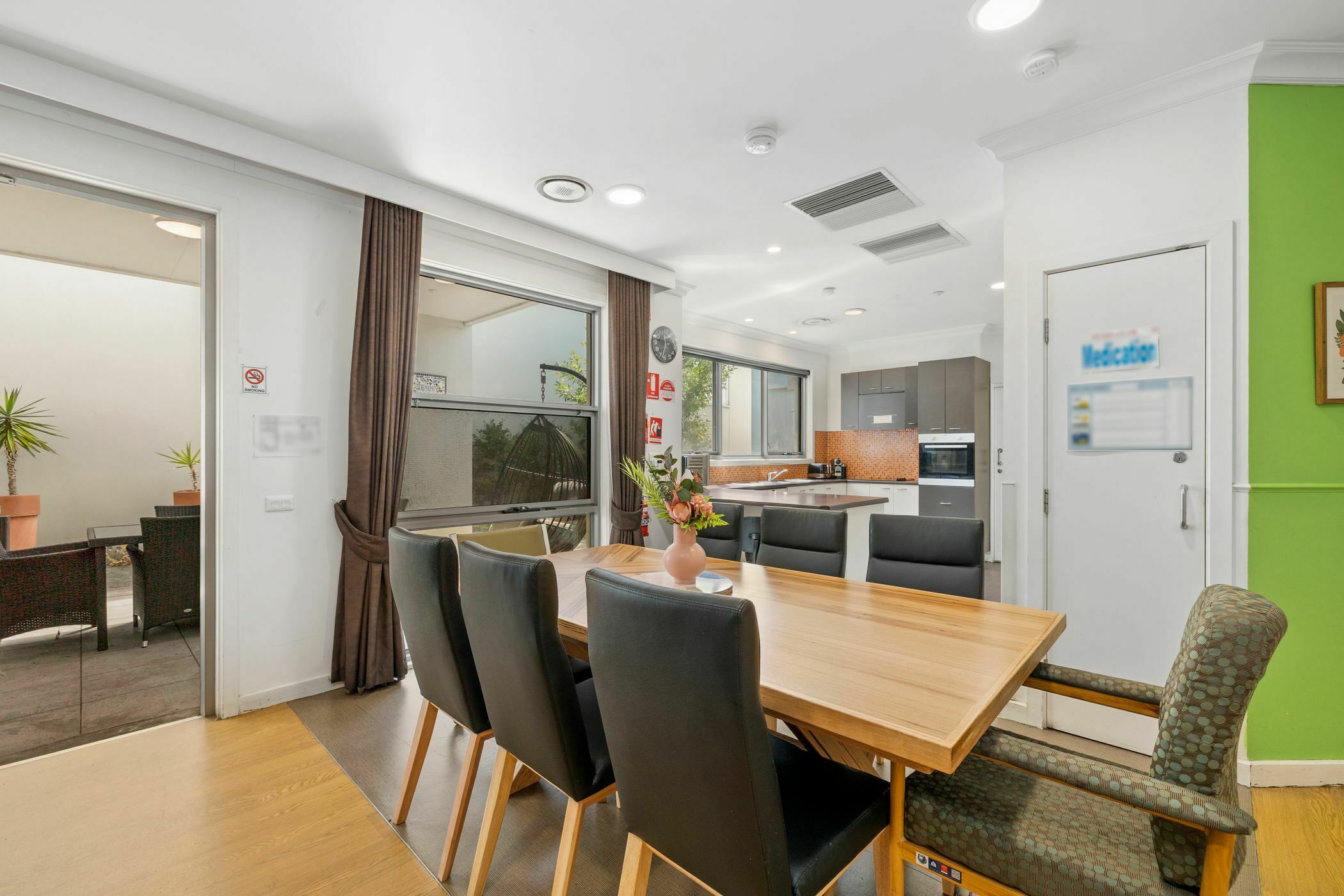 Dining area with wooden table in SDA home in Kew