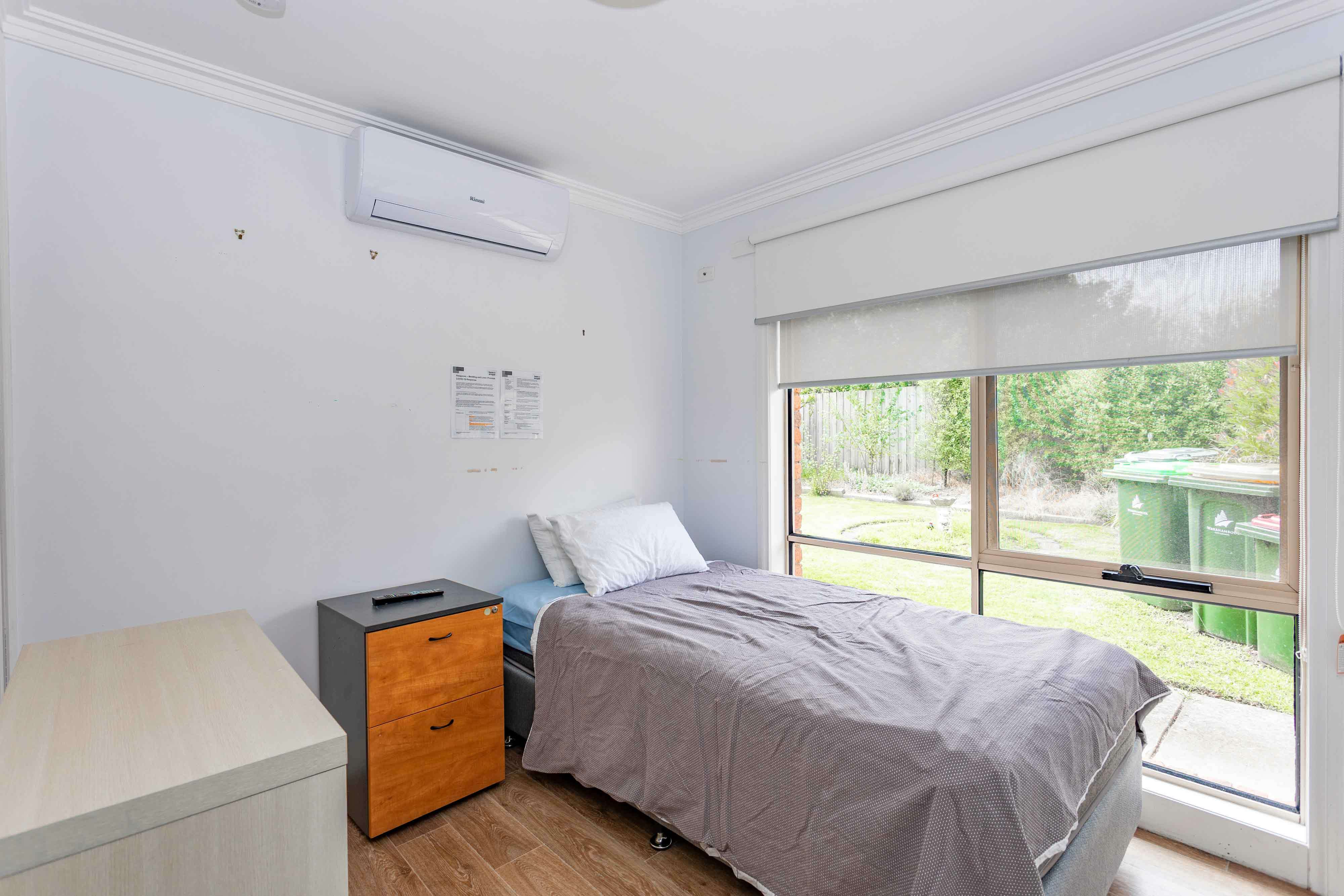 Bedroom with orange bedside table and air conditioning