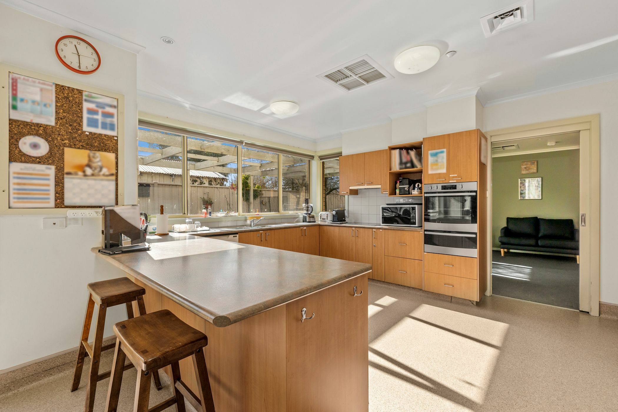 Kitchen area with wooden cabinets and large windows