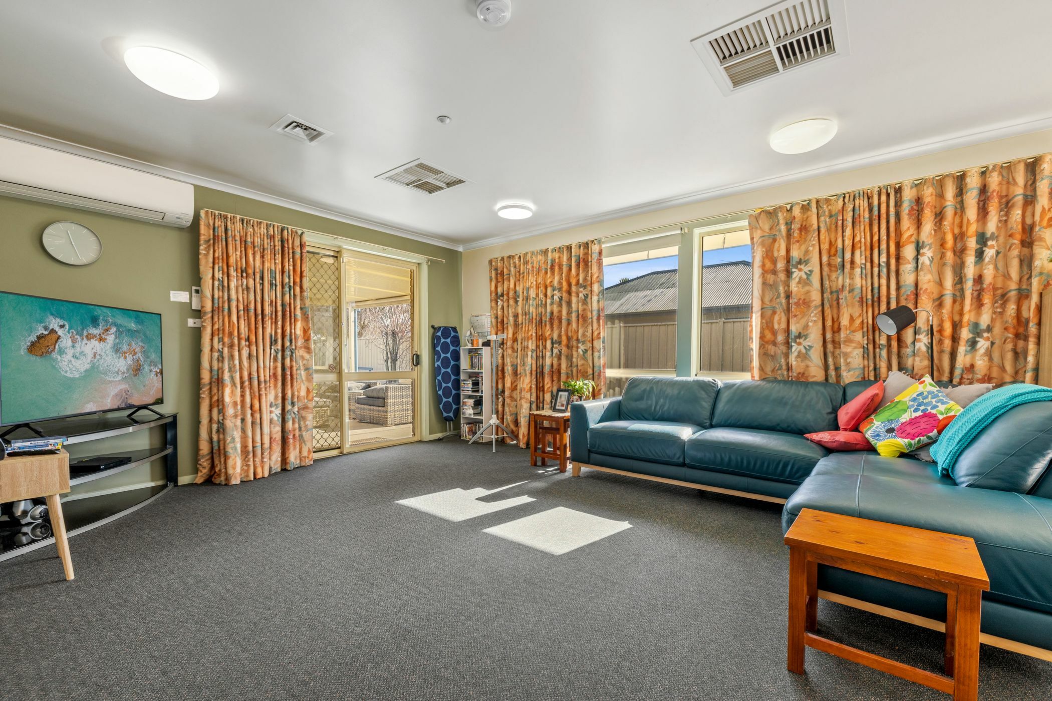 Living area with teal couches and large tv