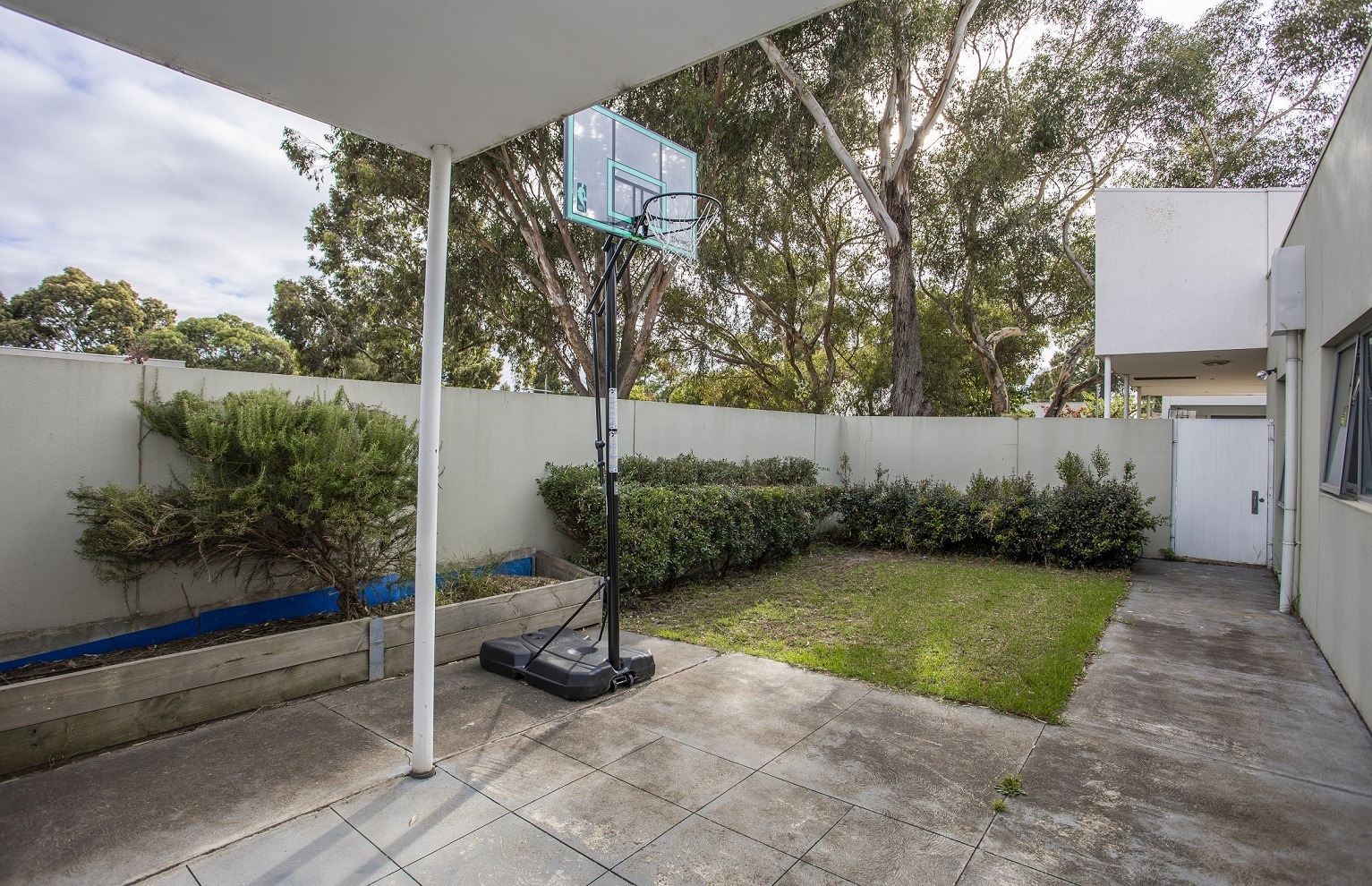 Undercover area with basketball ring and lawn area