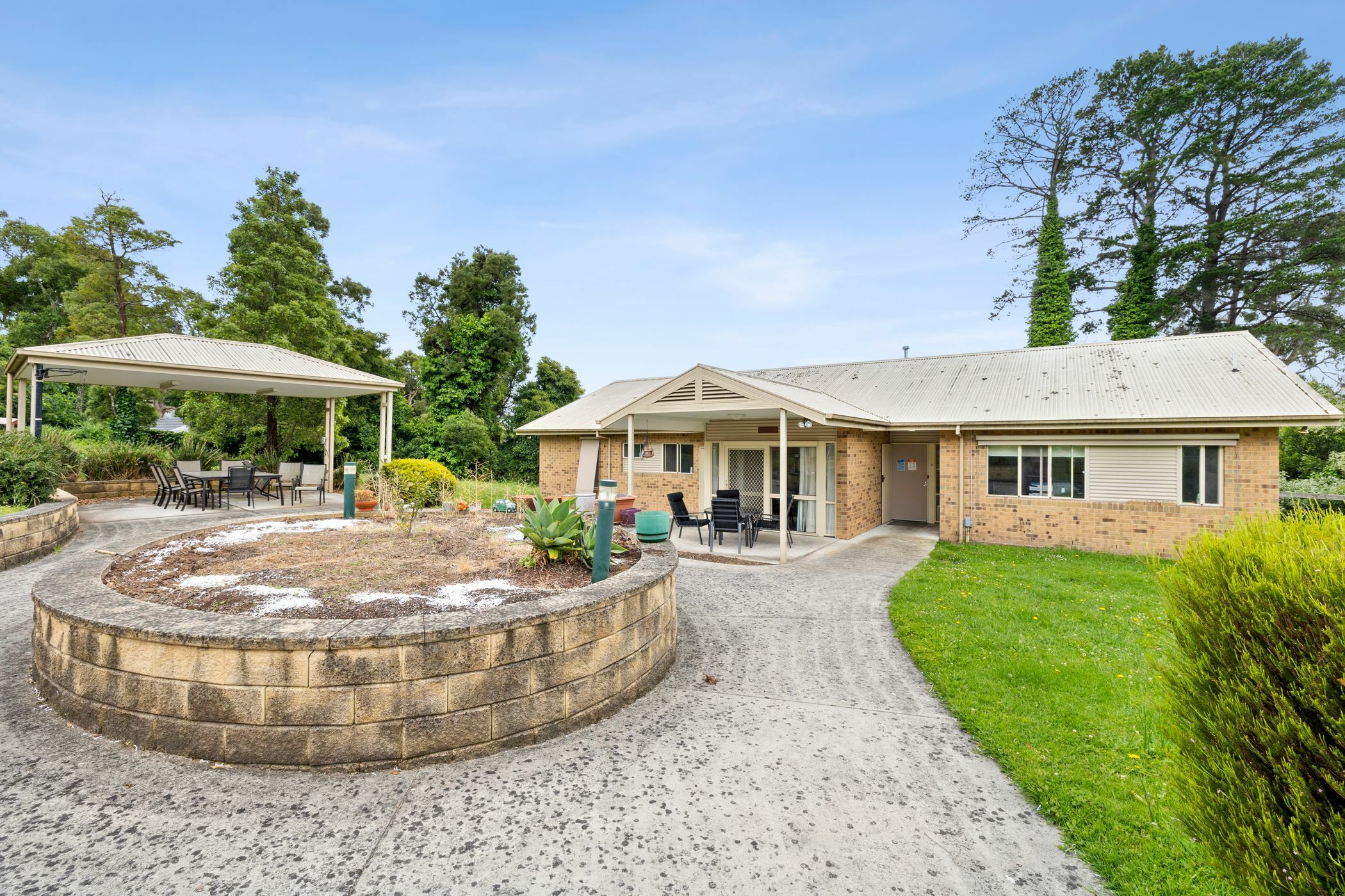 Frontyard with table and chairs and pagola and island roundabout