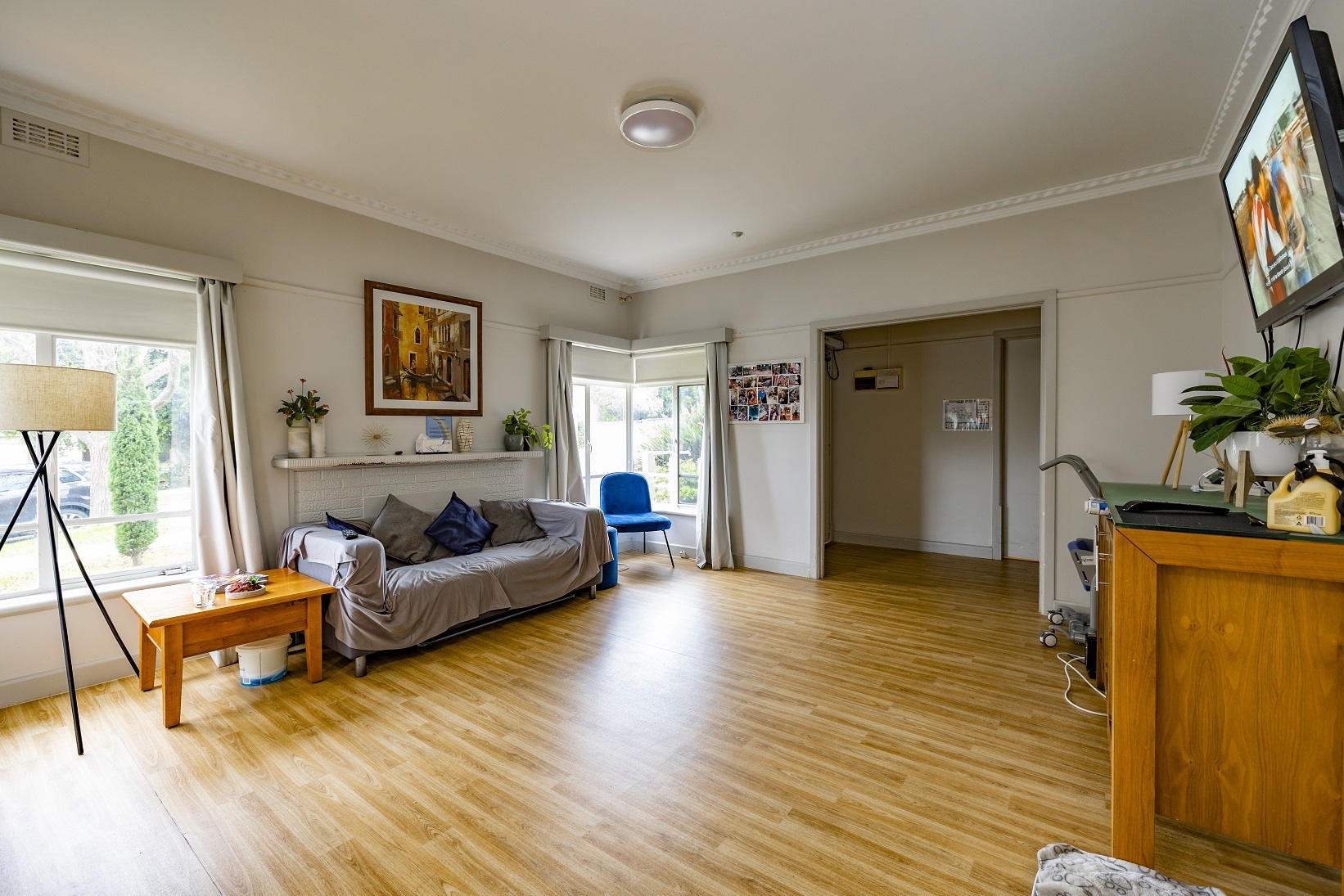 Well lit and spacious living room area with windows looking out to front yard